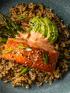 A plate of salmon, avocado, and veggies.