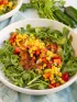 A bowl of grilled tilapia on a salad of arugula and corn for a heart and diabetes healthy dash diet