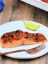 Salmon filet on white plate with harissa sauce and California dates