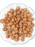 Spiced peanuts with sesame seeds on a clear glass plate.