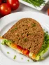 Sandwich on wheat bread with lettuce, colorful bell peppers, hummus