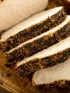 Sliced, seasoned pork loin on a cutting board