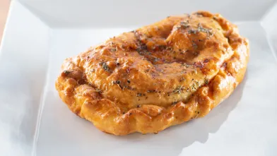 A whole wheat hot pocket on white plate