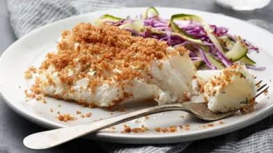 baked cod on a plate with a side of salad