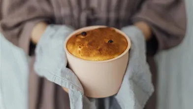 Person holding freshly baked cake
