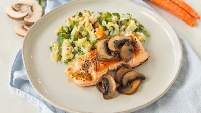 Salmon with mushrooms and potato mash and vegetables on plate.