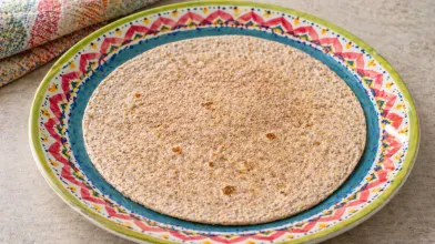 Whole wheat tortilla on a colorful patterned plate.