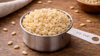 cooked brown rice in a 1/2 cup stainless steel measuring cup