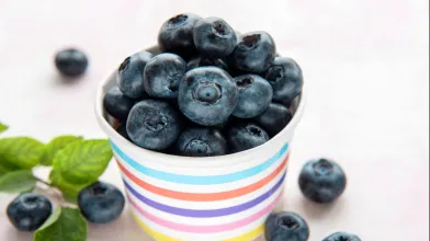 1 cup of blueberries in a brightly stripe colored container