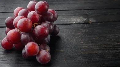bunch of red grapes on wooden table