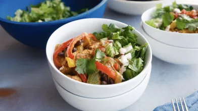 Chicken, black bean, red and green pepper bowl with cilantro, onion.