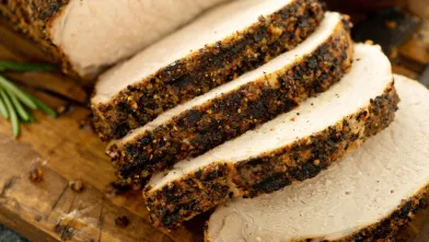 Sliced, seasoned pork loin on a cutting board