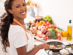 A woman cooks veggies at the stovetop