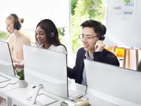Three call center agents are working at their desks.