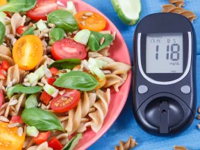 healthy pasta salad next to blood glucose level on blood glucose meter