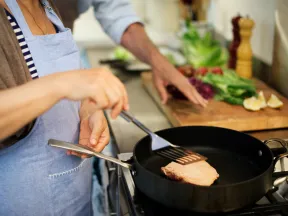 woman frying up lean meat in skillet
