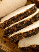 Sliced, seasoned pork loin on a cutting board