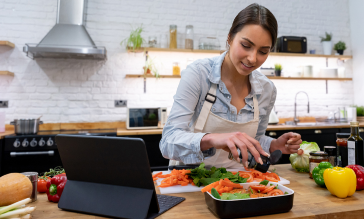 Woman in kitchen taking online cooking class