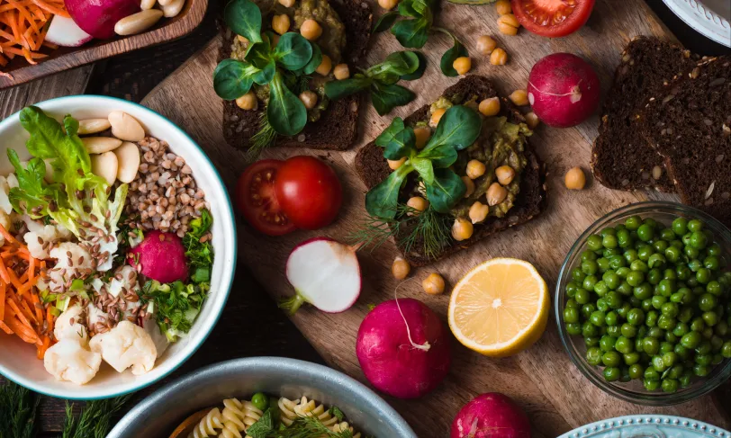 overhead shot of vegetables and salads on wood plank