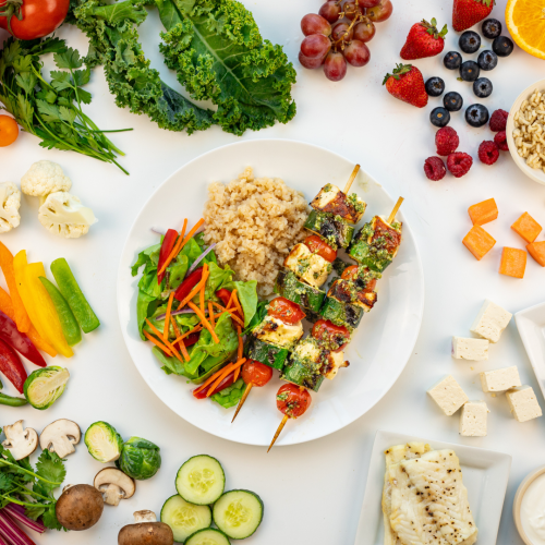 A plate with a low carb meal following the Diabetes Plate surrounded by veggies, lean protein, and fruit