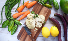 A chopping board with cauliflower surrounded by veggies perfect for a healthy diabetic diet