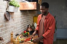 A man preparing a solo meal for himself that is healthy and diabetic friendly with veggies