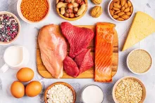 An assortment of protien rich foods like chicken, steak, salmon, almonds, eggs, and nuts. 