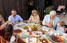Multi-generational family eating healthy meal at picnic table