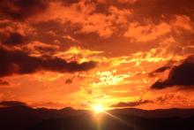 Fiery sunset over dark landscape