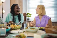 Smiling women at table eating healthy food