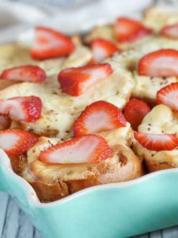 A blue casserole dish with strawberry french toast casserole