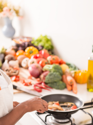 A woman cooks veggies at the stovetop