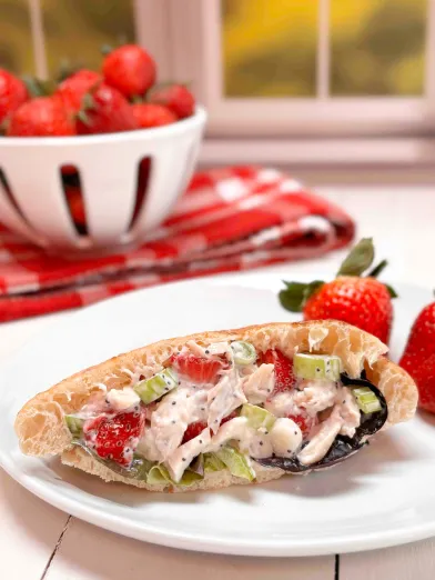 A sandwich with strawberry chicken salad filling on a plate. 
