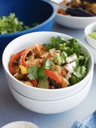 Chicken, black bean, red and green pepper bowl with cilantro, onion.