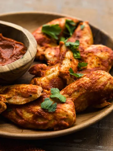 Lean chicken tenders coated in BBQ sauce, served with a dipping sauce.