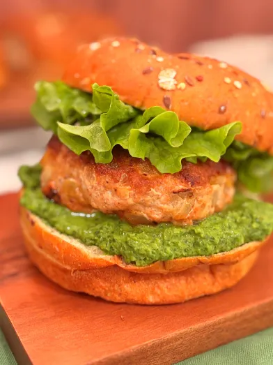 Turkey burger on whole grain bun with sauce and lettuce.