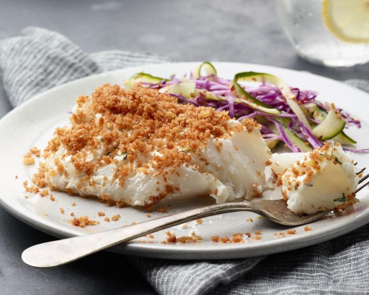 baked cod on a plate with a side of salad