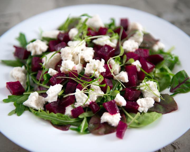 Beet and arugula salad with feta cheese in white bowl