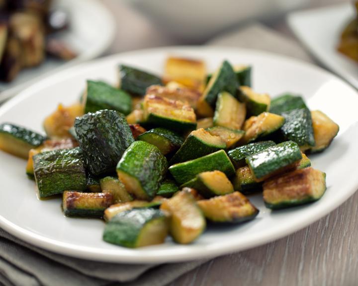 Cubes of roasted zucchini on a white plate