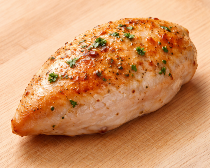 2 ounce piece of cooked chicken breast on wood cutting board