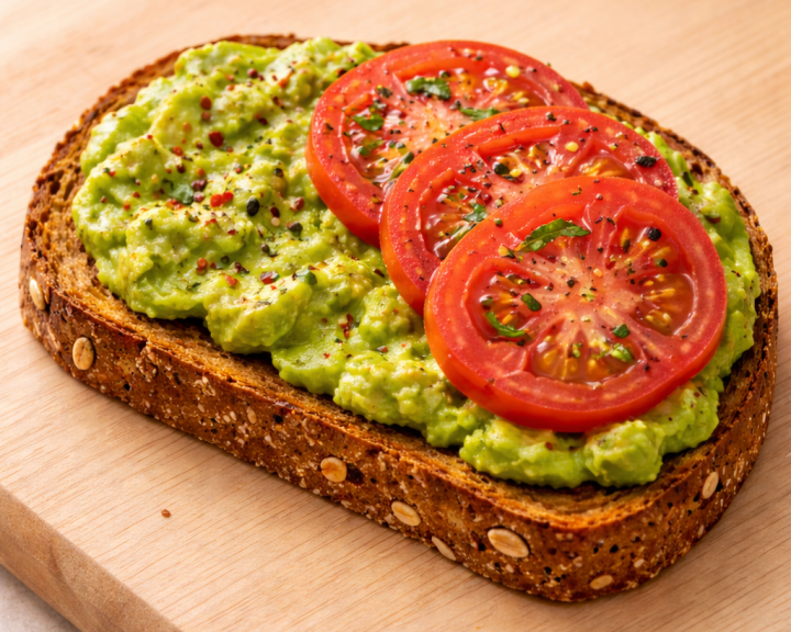 Avocado spread on whole grain toast with 3 tomato slices