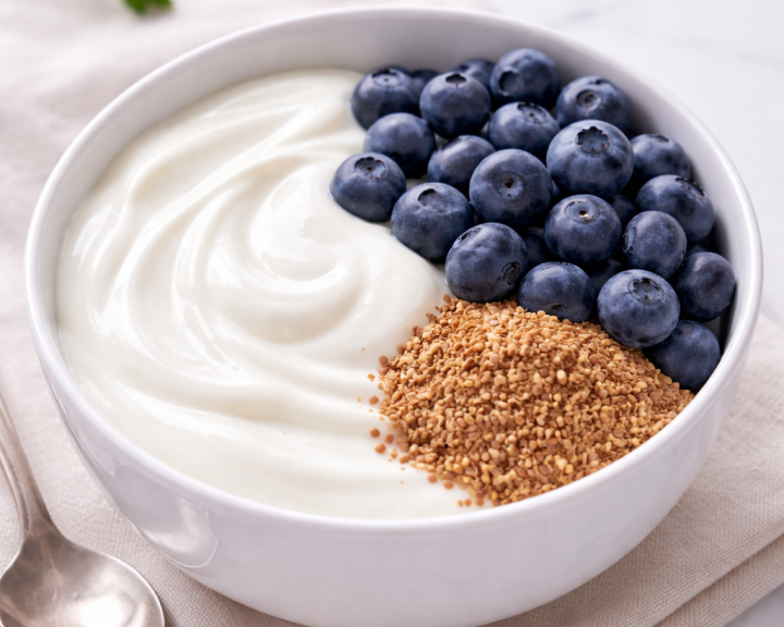 White bowl with plain yogurt, flax seeds, and fresh blueberries