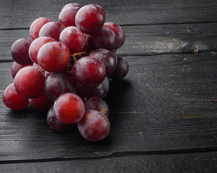 bunch of red grapes on wooden table
