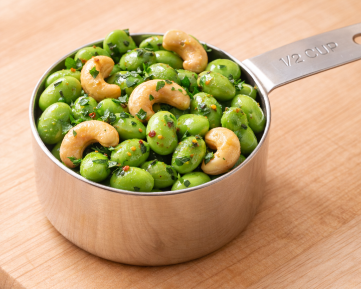 edamame and cashews with lemon and herbs in a 1/2 cup measuring cup