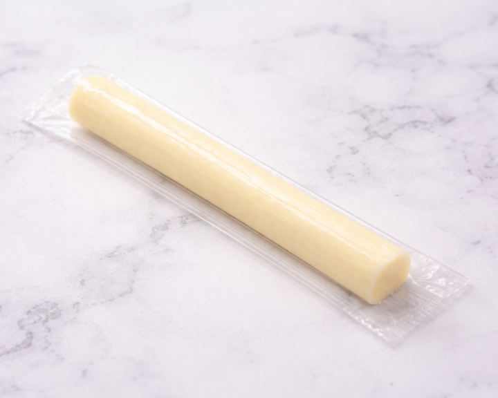 Single low-fat mozzarella cheese stick in plastic wrapping on countertop