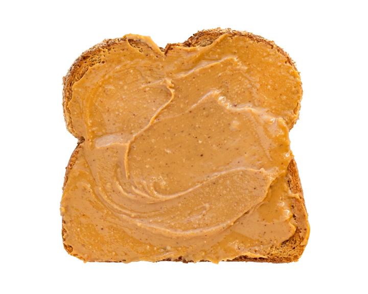 Slice of toast with peanut butter spread.