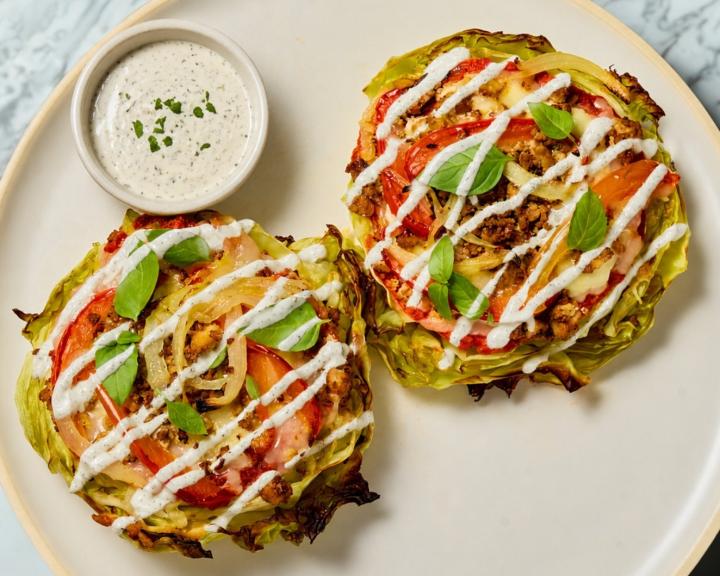 two cabbage pizzas on a plate with ranch style dressing