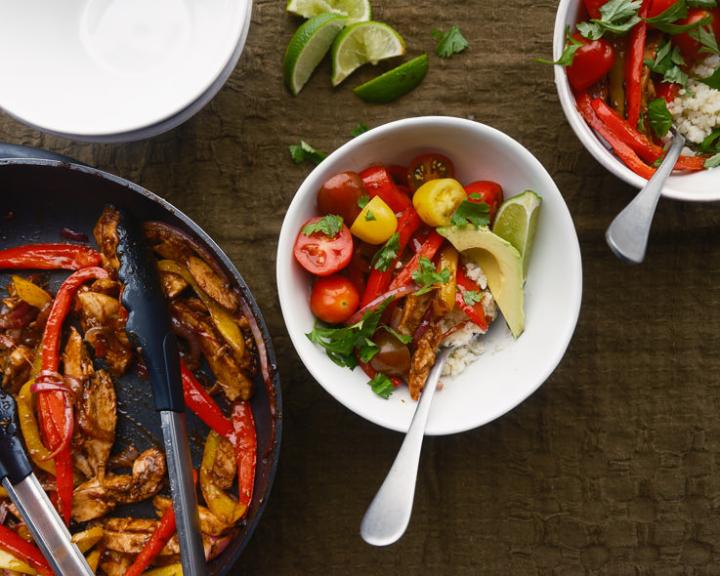 Chicken fajita bowl with cauliflower rice, cherry tomatoes, and avocado slices