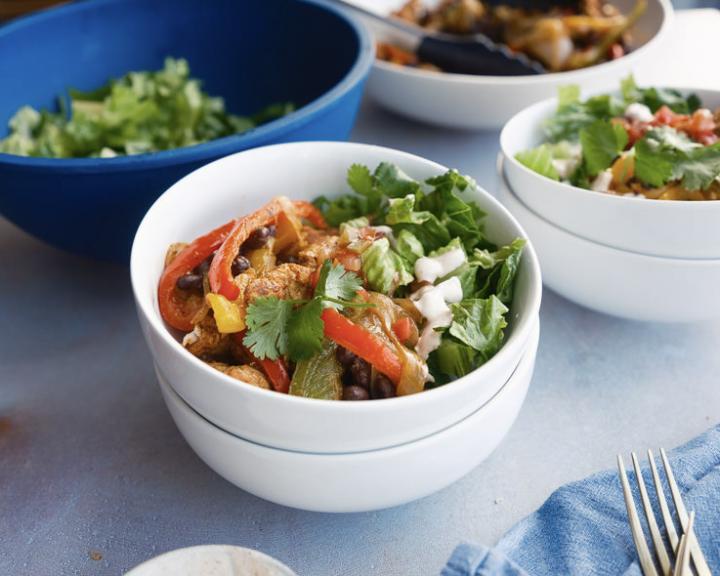Chicken, black bean, red and green pepper bowl with cilantro, onion.