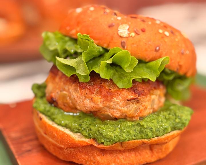 Turkey burger on whole grain bun with sauce and lettuce.